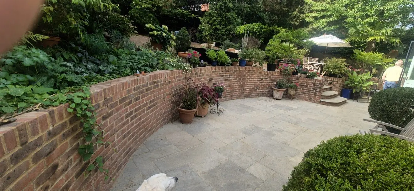The curved retaining wall and paving